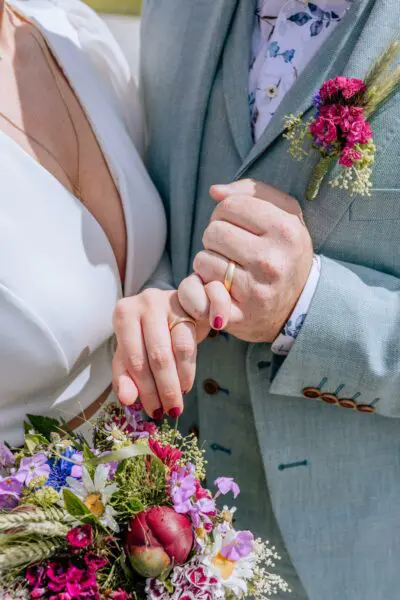 Brautpaar mit Strauß und Anstecker - Fotografin: storiesbyjulia