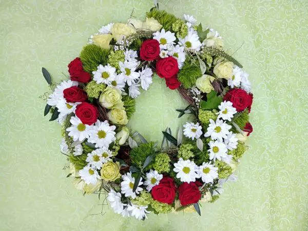 rundgesteckter Blütenkranz mit Rosen und Chrysanthemen
