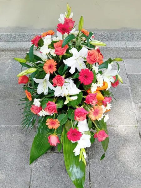 Sargbukett rot weiß mit Lilien und Rosen
