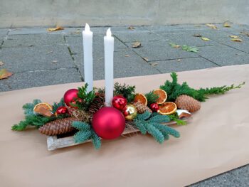 Advent Gesteck mit Orangen und roten Kugeln und Dauerkerzen