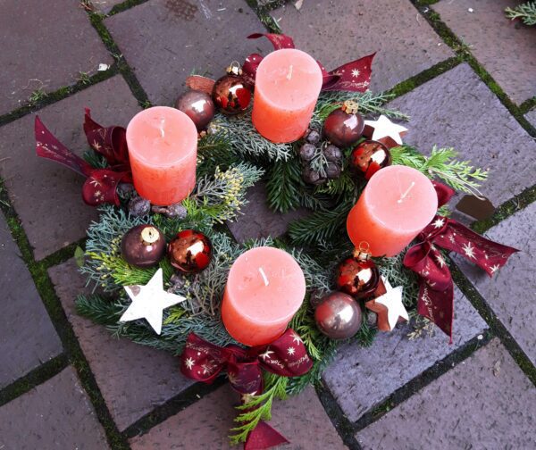 Adventskranz mit Kugeln und lachsfarbenen Kerzen